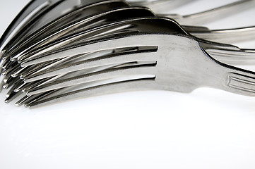 Image showing Forks arranged in series on the kitchen table.