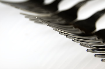 Image showing Forks arranged in series on the kitchen table.