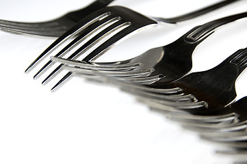 Image showing Forks arranged in series on the kitchen table.