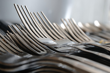 Image showing Forks arranged in series on the kitchen table.