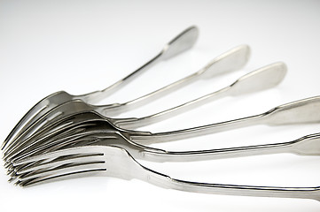 Image showing Forks arranged in series on the kitchen table.