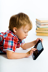 Image showing boy lying on the floor with tablet computer