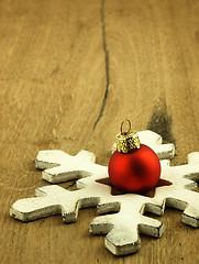 Image showing Red Christmas bauble on a wooden oak background.