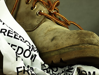 Image showing The word freedom crushed by a heavy, old military boot.