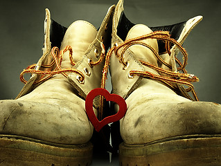 Image showing Pair of heavy military boots and red heart.