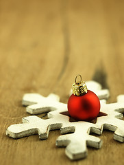 Image showing Red Christmas bauble on a wooden oak background.