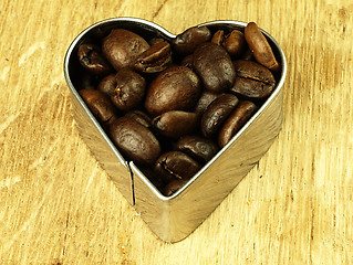 Image showing Heart and Coffee beans close-up on wooden, oak table.