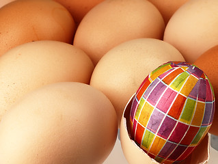 Image showing Colorful Easter egg in the company of ordinary eggs.