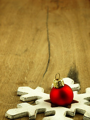 Image showing Red Christmas bauble on a wooden oak background.