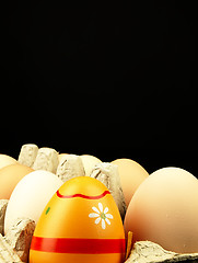 Image showing Colorful Easter egg in the company of ordinary eggs.