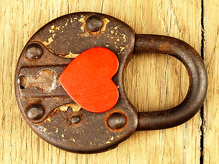 Image showing Rusty padlock and heart on a wooden background.