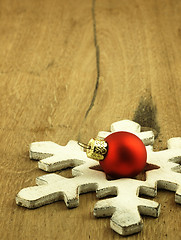 Image showing Red Christmas bauble on a wooden oak background.