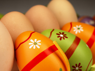 Image showing Colorful Easter eggs in the company of ordinary eggs.