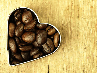 Image showing Heart and Coffee beans close-up on wooden, oak table.