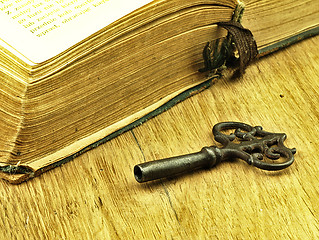 Image showing Key and old, open book with a damaged cover.