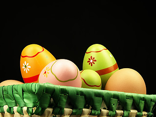 Image showing Colorful Easter eggs in the company of ordinary eggs.