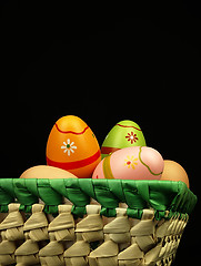 Image showing Colorful Easter eggs in the company of ordinary eggs.