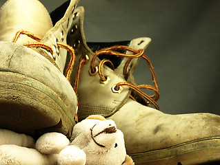 Image showing Teddy bear crushed by a heavy, old military boot.