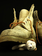 Image showing Teddy bear crushed by a heavy, old military boot.