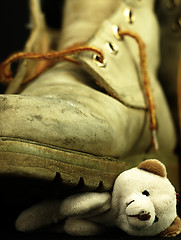 Image showing Teddy bear crushed by a heavy, old military boot.