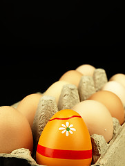 Image showing Colorful Easter egg in the company of ordinary eggs.