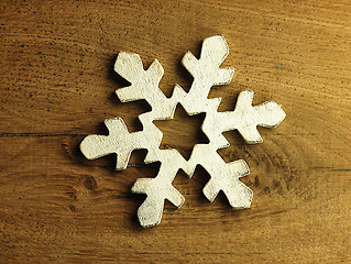 Image showing Huge white snowflake and wooden background.