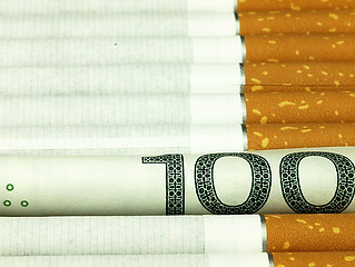 Image showing Cigarettes and money. Expensive habit.