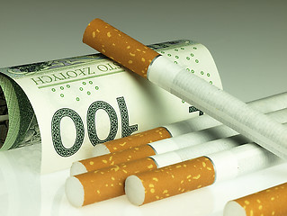 Image showing Cigarettes and money. Expensive habit.