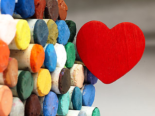 Image showing Heart and colored dry pastels closely.