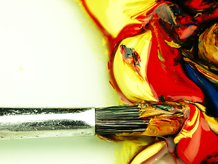 Image showing Colored paint mixed on palette. Dirty brush in the foreground.