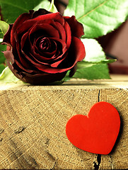 Image showing Red rose and red heart on a wooden table.