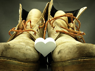 Image showing Pair of heavy military boots and white heart.