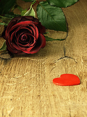 Image showing Red rose and red heart on a wooden table.