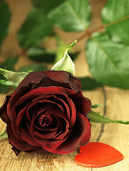 Image showing Red rose and red heart on a wooden table.