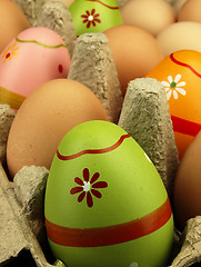 Image showing Colorful Easter eggs in the company of ordinary eggs.