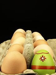 Image showing Colorful Easter egg in the company of ordinary eggs.