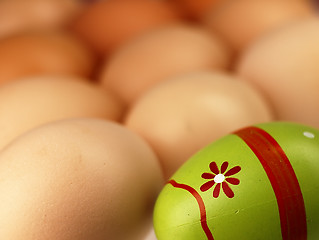 Image showing Colorful Easter egg in the company of ordinary eggs.