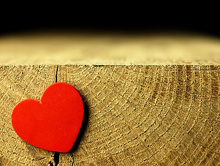 Image showing Red heart on the edge of a wooden table.