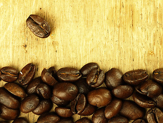 Image showing Coffee beans close-up on wooden, oak table.