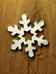 Image showing Huge white snowflake and wooden background.