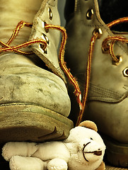 Image showing Teddy bear crushed by a heavy, old military boot.