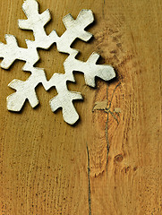 Image showing Huge white snowflake and wooden background.