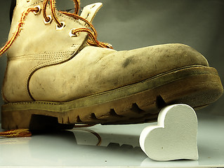 Image showing Heavy military boot trampling heart.