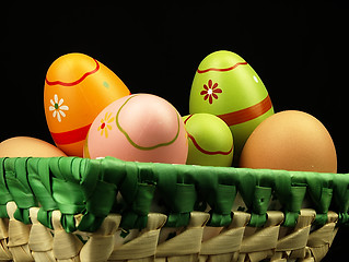 Image showing Colorful Easter eggs in the company of ordinary eggs.