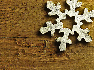 Image showing Huge white snowflake and wooden background.