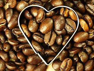Image showing Heart and Coffee beans close-up on wooden, oak table.