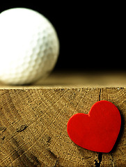 Image showing Golf ball and heart on the edge of table.