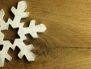 Image showing Huge white snowflake and wooden background.