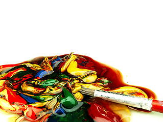 Image showing Colored paint mixed on palette. Dirty brush in the foreground.