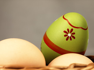 Image showing Colorful Easter egg in the company of ordinary eggs.